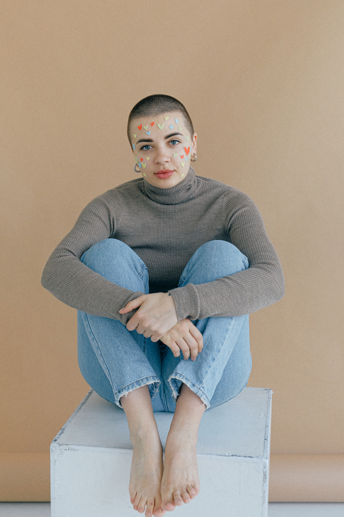 Woman In Gray Turtleneck Sweater And Blue Denim Jeans Sitting 